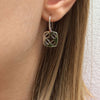 Sterling silver earrings shown on model hanging close to earlobe..