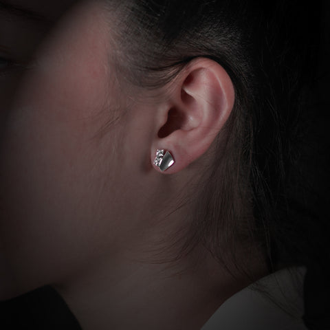 Small earring studs in combined matt and polished finish, showing one on model.