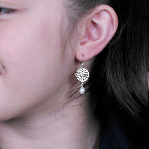 Silver cut-out disc with freshwater pearl drop. Shown on model.