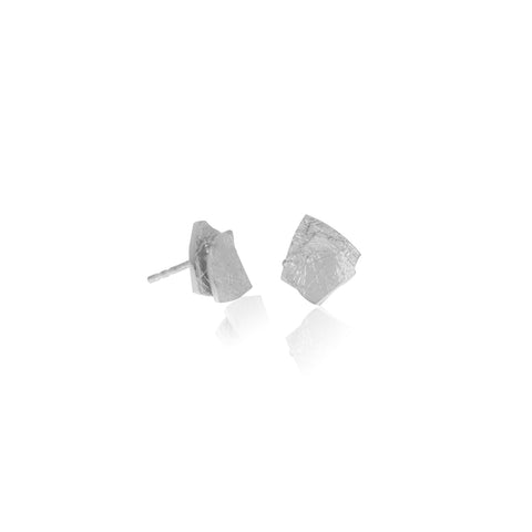 Layered square of silver earring studs. Shown sitting on table.