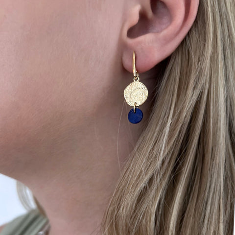 Gold and lapis lazuli drop earrings shown on model.