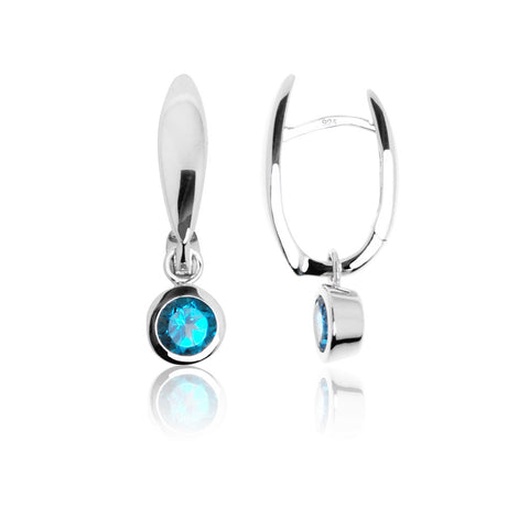 Sterling silver huggie earrings featuring a blue topaz stone in a bezel setting.  The earrings are hinged enabling the post to open and close.