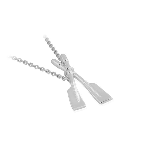 Rowing oars pendant is a sterling silver slider pendant - the bale is concealed behind the point where the oars cross. It's hung on a sterling silver Belcher chain. Pendant shown with partial chain on table.