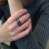 Narrow, square-shaped, sterling silver ring with black enamel inset, 4mm wide, shown on model. Model wearing two rings.