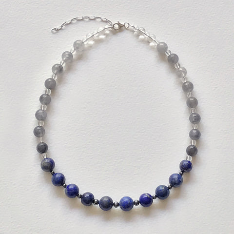Lapis Lazuli and Smokey Quartz Beaded Necklace by Antika. Polished cabochon gemstones with round Haematite and glass bead spacers. The necklace is 40cm long + 5.5cm sterling silver extension chain with lobster closure. The round Lapis Lazuli beads are 10mm in diameter and the round Smokey Quartz beads are 8mm in diameter.