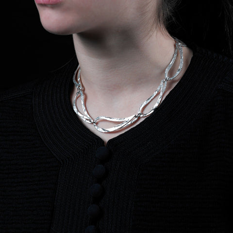 9-links silver choker necklace shown on model.
