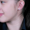 Silver tear drop stud earrings shown on model.